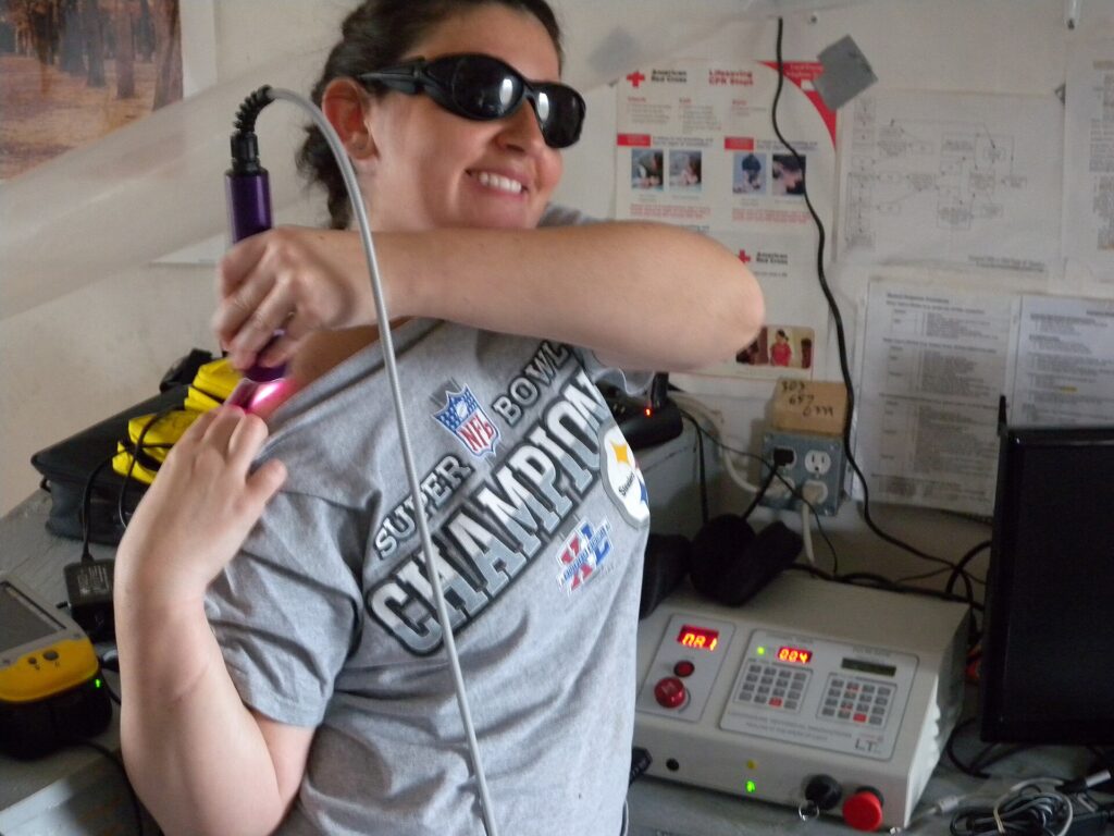 Person using a Class IV high-power laser therapy device on a patient