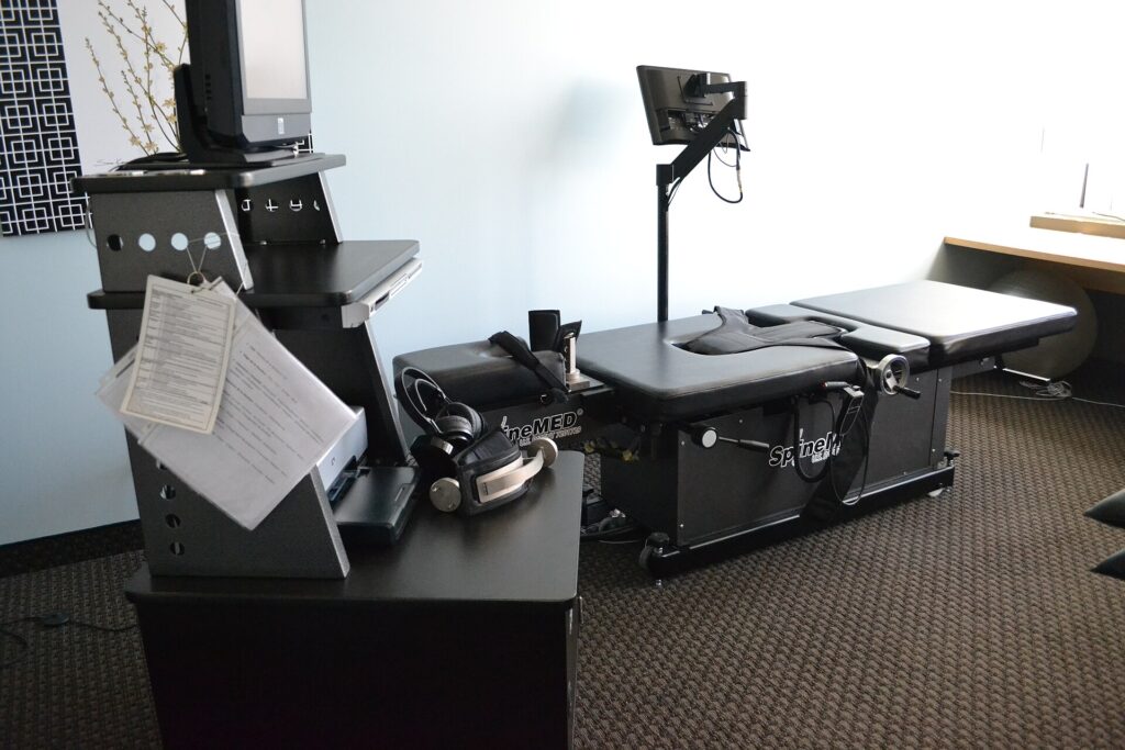 Computer-controlled spinal decompression table with a padded treatment bed