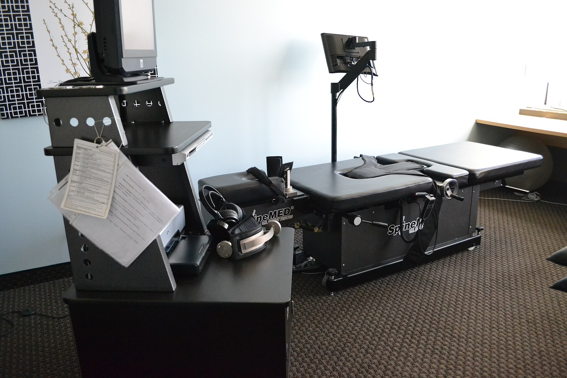 Computer-controlled spinal decompression table with a padded treatment bed